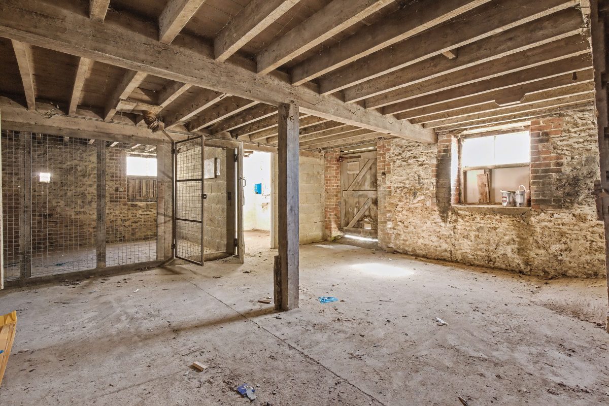 Inside a stone outbuilding at Purwell Farmhouse, with exposed timber beams and old stalls