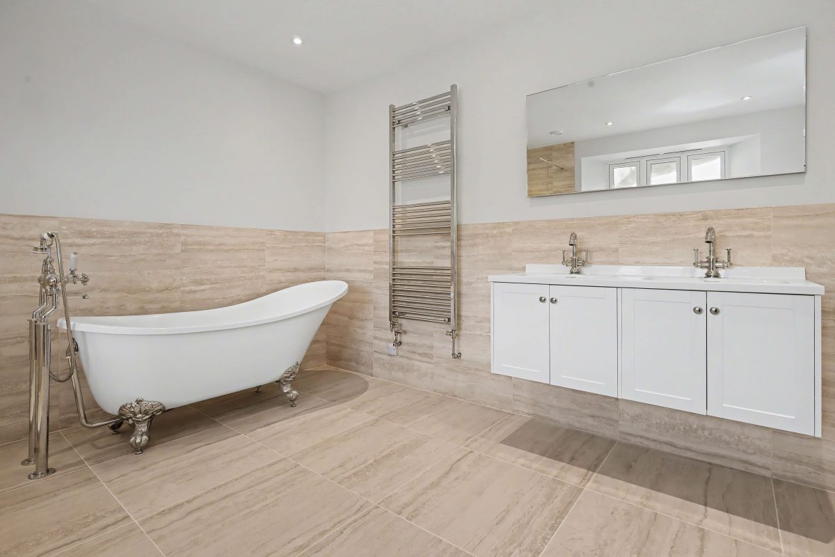Bathroom at Purwell Farmhouse with a freestanding roll-top bath and a double vanity unit
