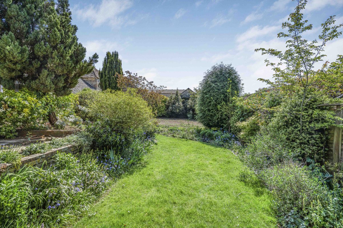 A long lawn between deep planted borders in the garden at Purwell Farmhouse