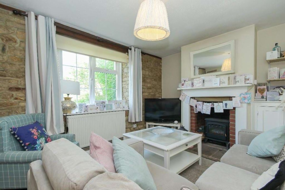 Living room at Grove Road with a wood-burning stove, sofas and a sash window