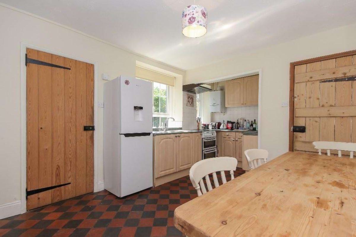 Kitchen and dining area at Grove Road with ledged pine doors and a tiled floor