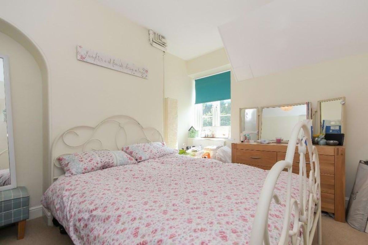 Bedroom at Grove Road with a cream metal bed and floral bedding