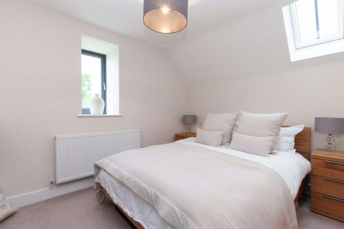 Bedroom at Littleworth Barn with a double bed, bedside lamps and a roof window