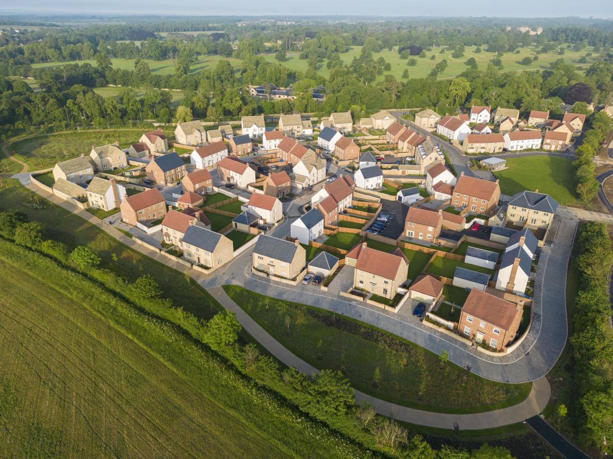 Aerial view of Park View homes on a winding road, with Blenheim Park beyond