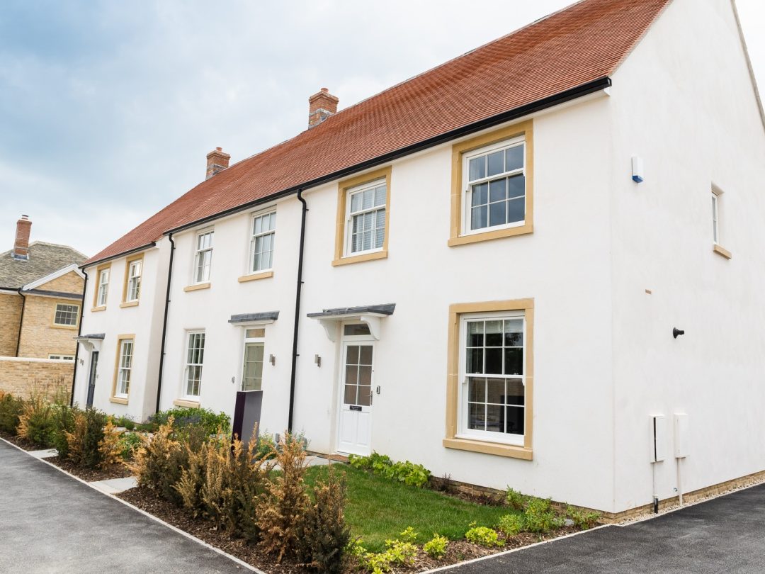 A terrace of white rendered rental homes at Park View with stone window surrounds and new planting