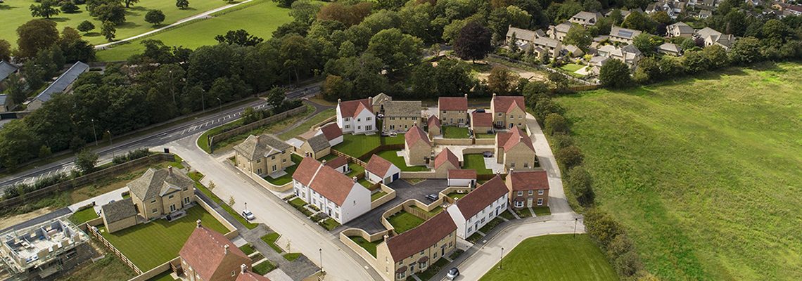 Aerial view of Park View, Woodstock, a new development of stone and red-roofed homes beside fields