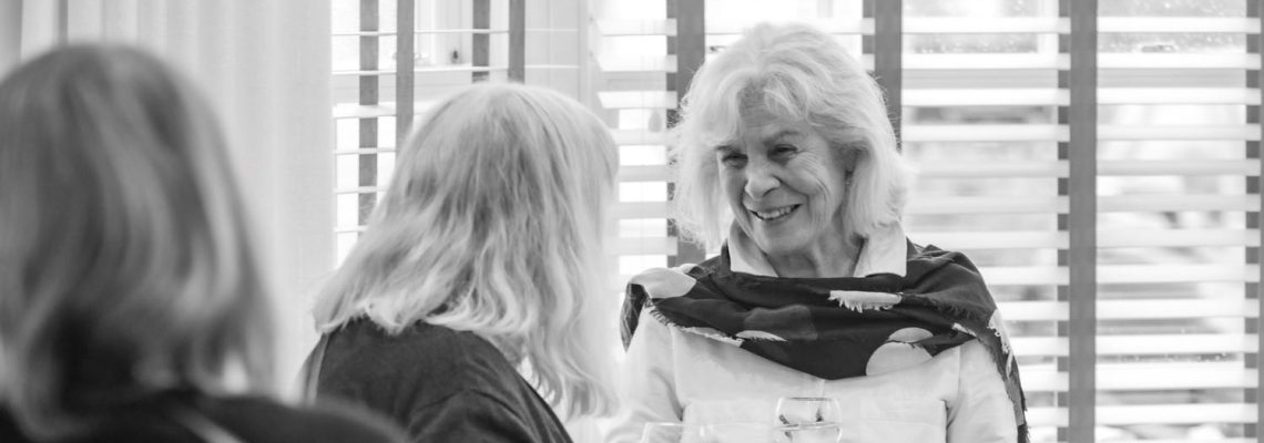 Guests smiling and chatting at a history talk for Park View residents, in black and white