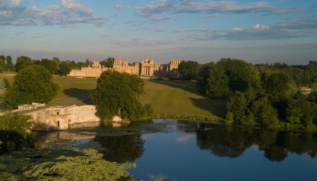 Blenheim Palace across the lake at sunrise, with the Grand Bridge on the left