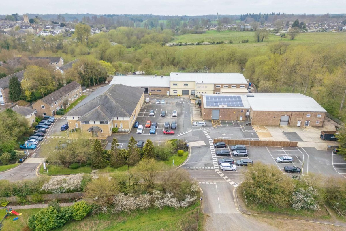 Aerial view of Brook Hill in Woodstock, a group of industrial and office buildings with car parks, surrounded by trees and housing