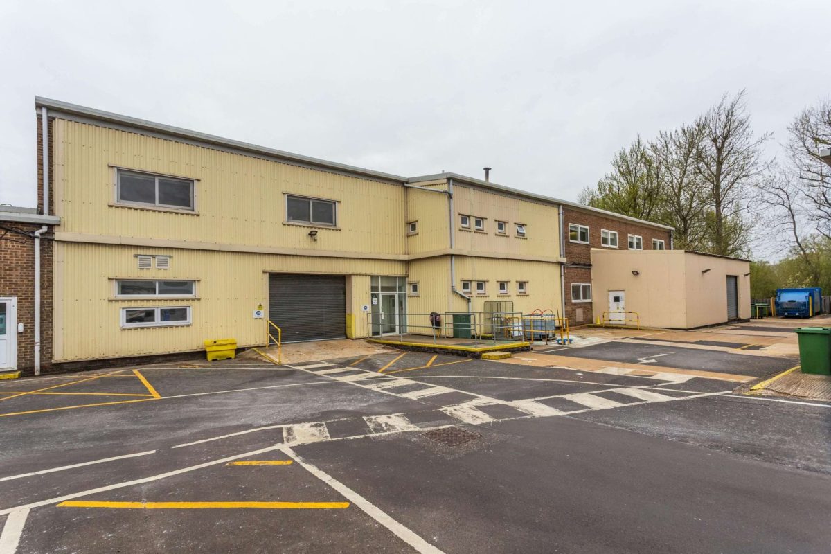 Exterior of a two-storey cream-clad industrial building with a roller shutter door at Brook Hill