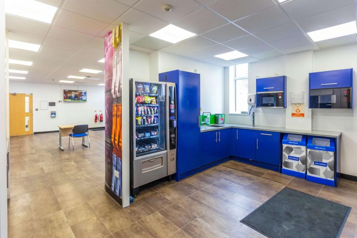 Staff kitchen and break area at Brook Hill with blue cabinets and a vending machine
