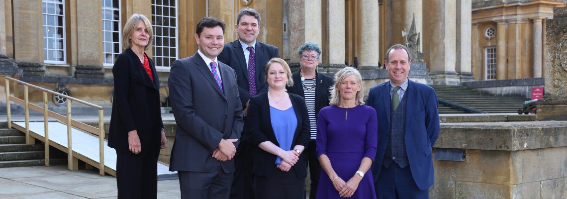 Seven guests at the affordable homes seminar standing on the steps of Blenheim Palace