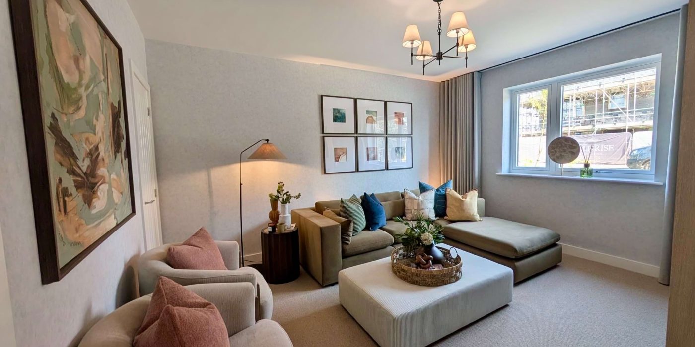 Living room in a Hill Rise show home with a corner sofa, armchairs, ottoman and framed artwork