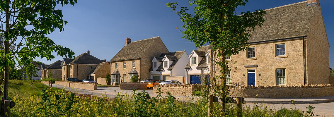 A street of new Cotswold stone and white rendered houses at Park View, Woodstock