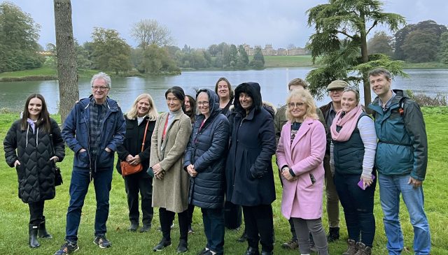 A group of photographers standing together on the grass beside the lake in Blenheim Park