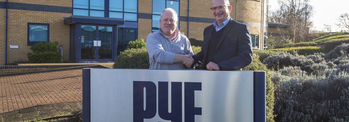 Two men shaking hands behind a Pye Homes sign outside the company's office