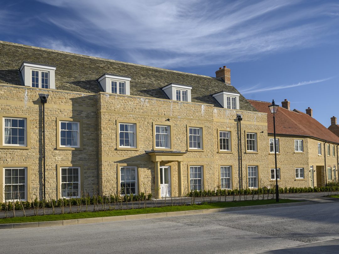 A three-storey stone apartment building with dormer windows on a street at Park View