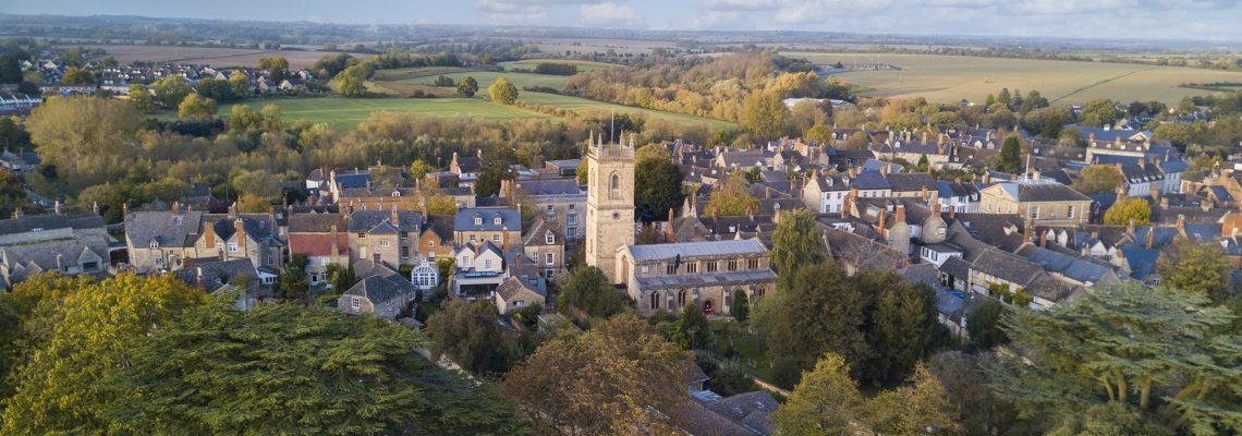 Aerial view of Woodstock, its church tower and rooftops, with countryside beyond