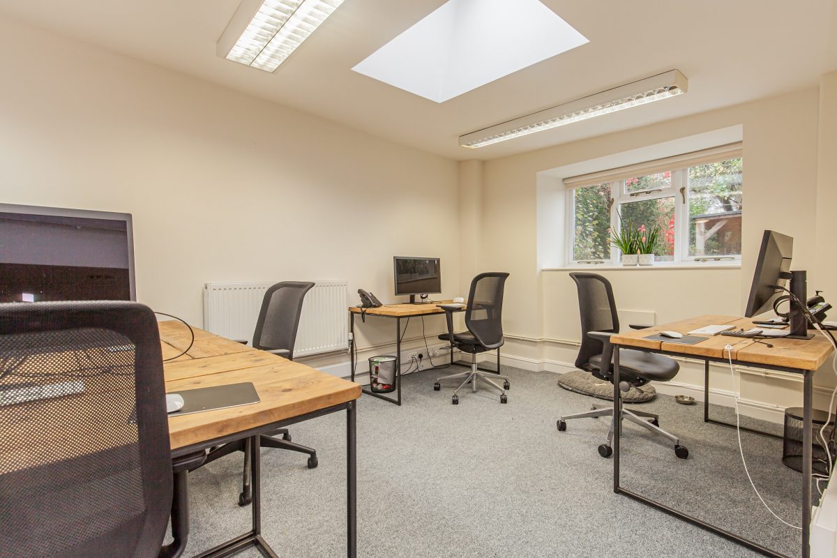 Office suite at Woodstock Lodge with wooden desks, office chairs and a skylight