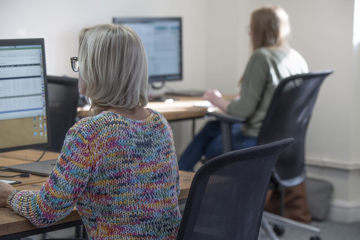 Two people working at computer desks in a serviced office at Woodstock Lodge